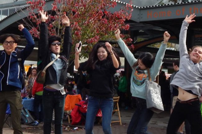A group of international student leap with joy into the air, fist pumping