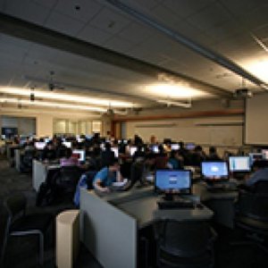 A lab filled with computers sits darkly lit.