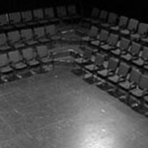 black and white photo of a tiled floor with rows of black seats