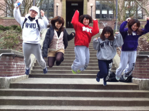AUAP students laugh and smile as they jump off the steps of Old Main at WWU.