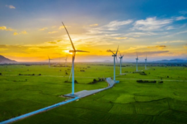 A row of modern solar windmills stand starkly outlined against a blue sky.