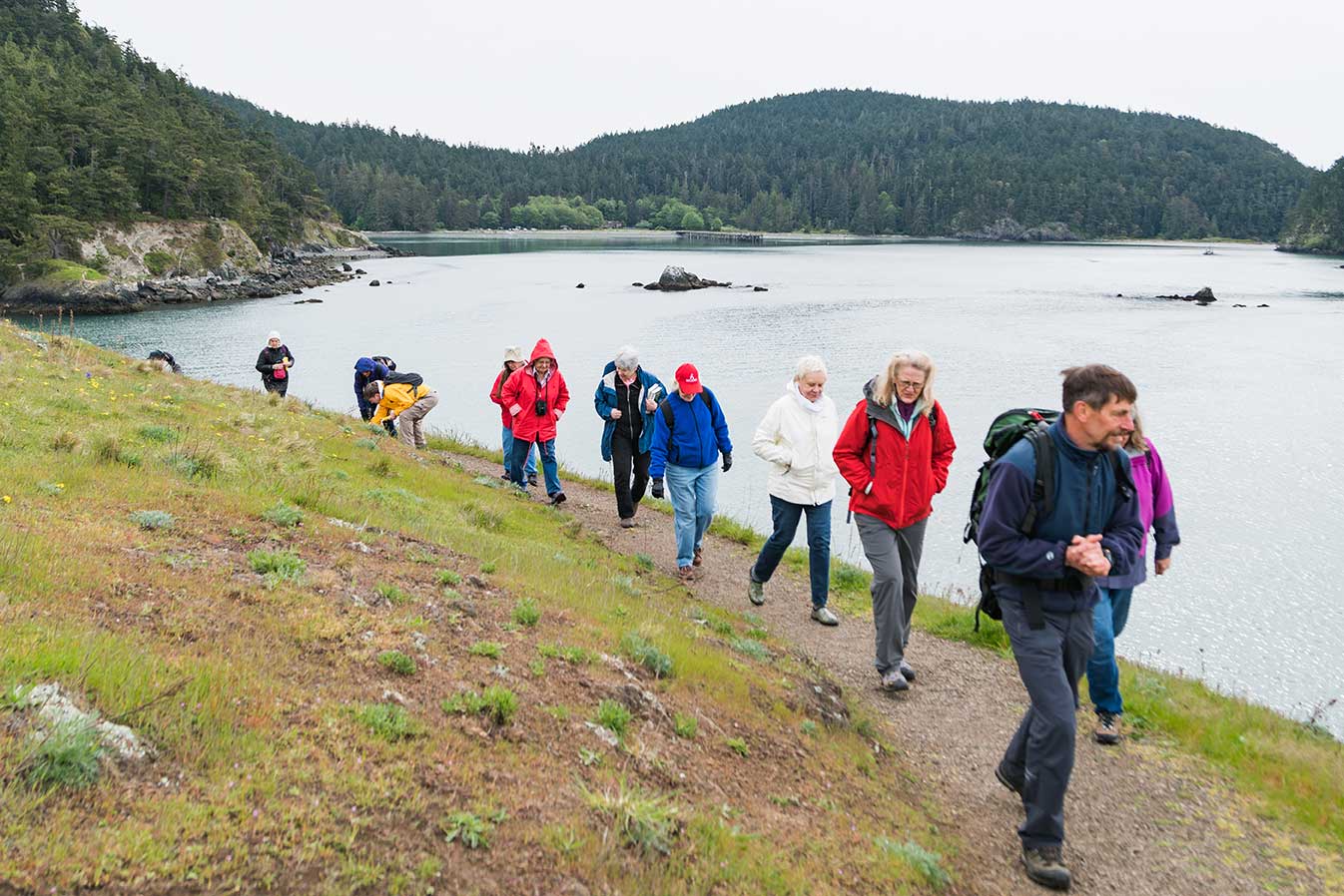 a group of ALL'ers walk a path on a hill at Deception Pass